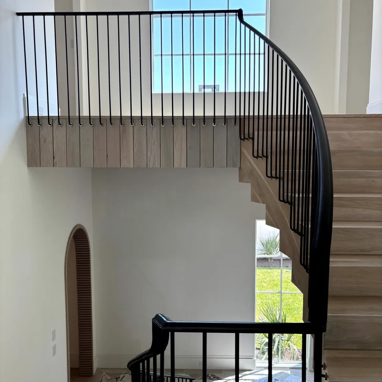 Curved wooden staircase in sunlight